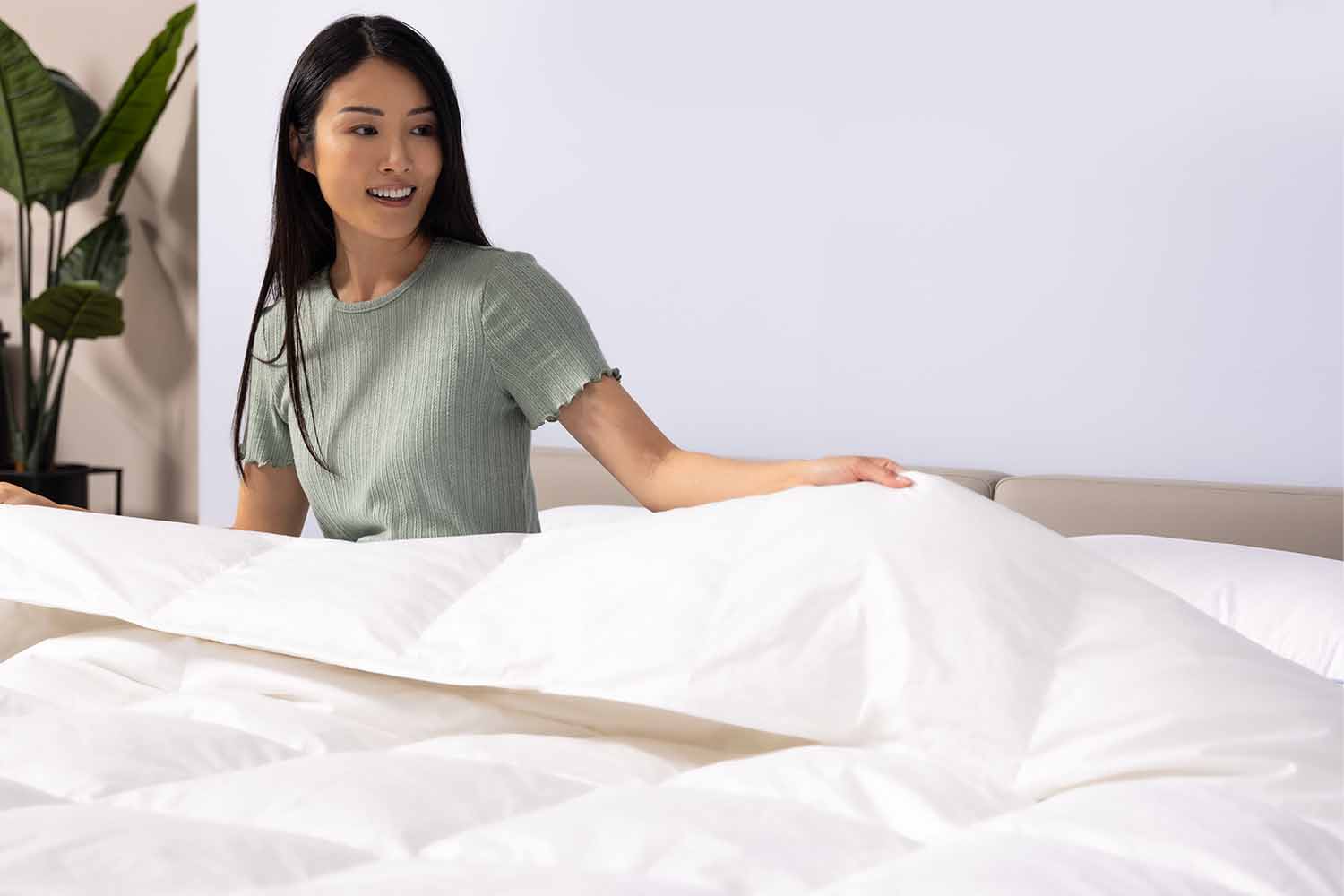 Woman on bed wrapped in Octave Down Duvet