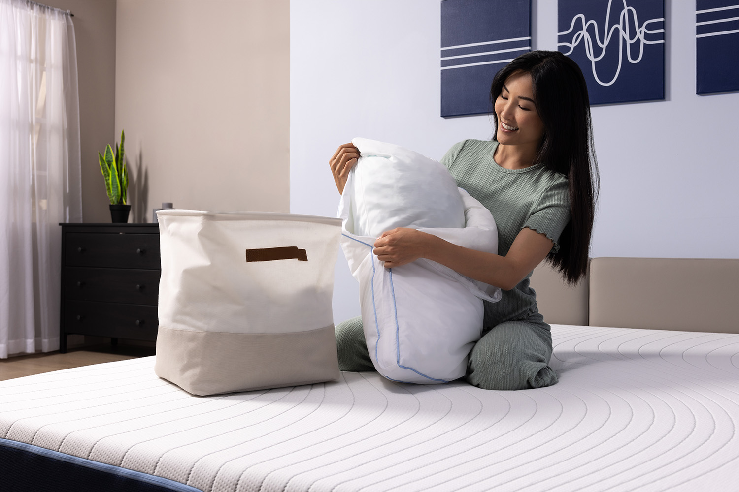 Woman removing her removable memory foam pillow cover and placing it in the laundry bin 