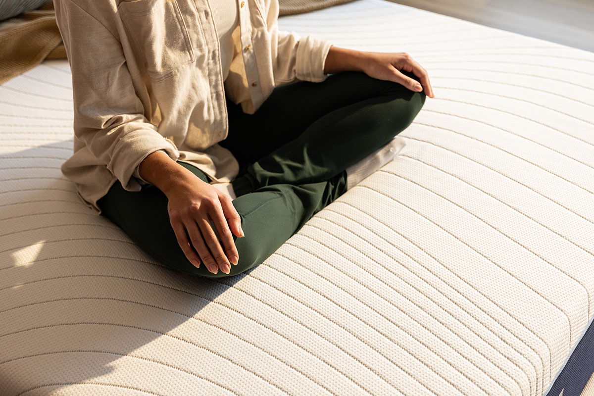 Woman sitting cross-legged on an Octave Vista mattress.