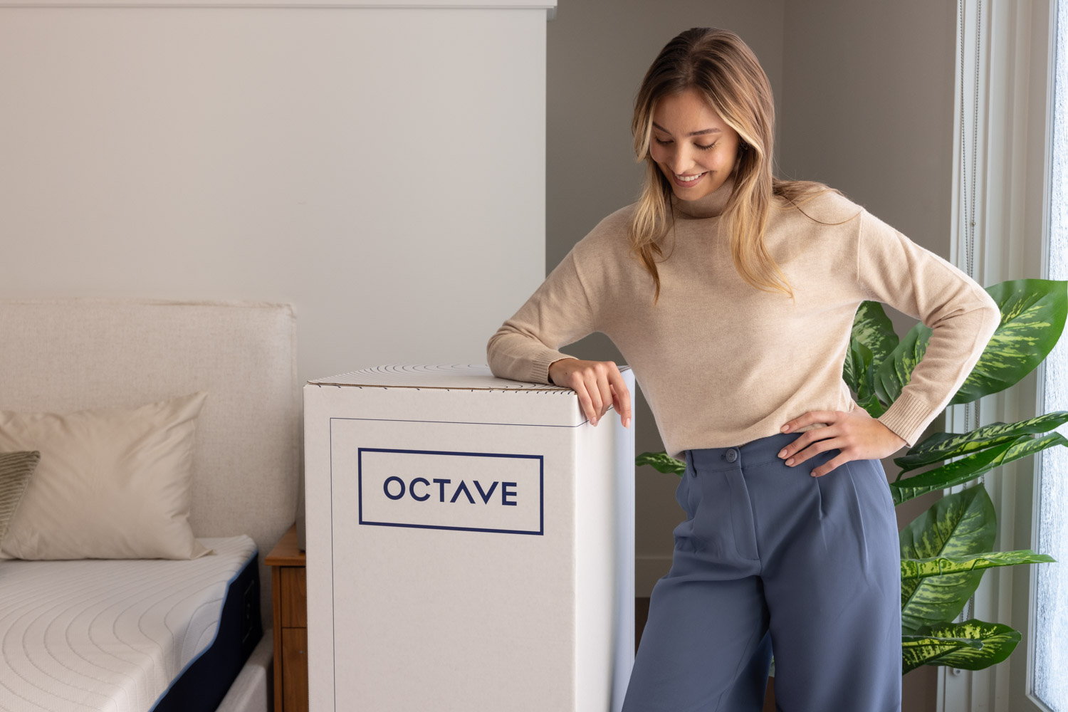 Femme souriante et déballant le matelas Octave