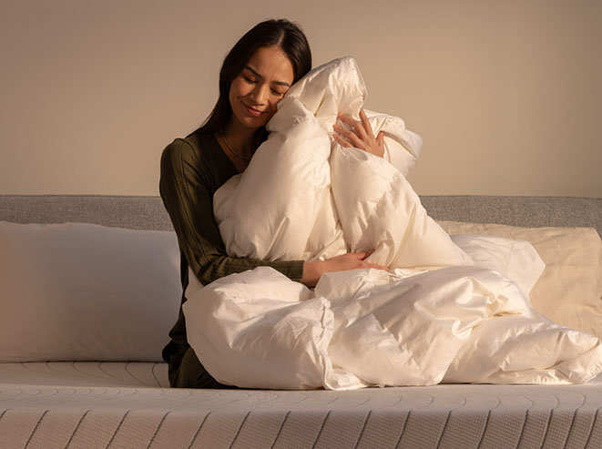 Une femme étreignant une couette en duvet canadien d’Octave.