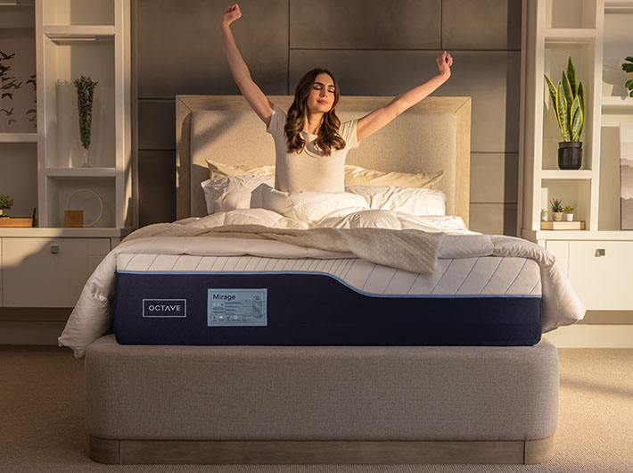 Une femme qui se réveille et s'étire les bras sur un matelas Octave Mirage.